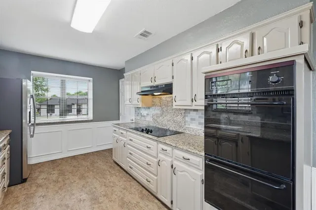 a kitchen with stainless steel appliances granite countertop a stove and cabinets