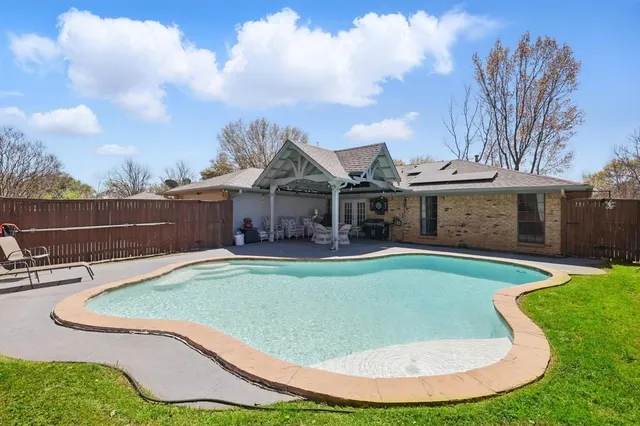 a view of a house with swimming pool and sitting area