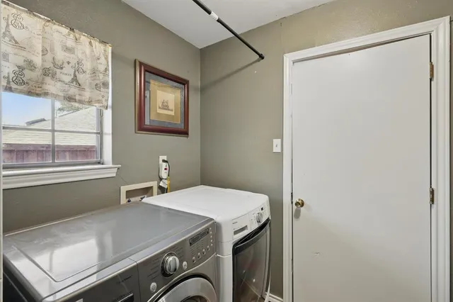 a utility room with dryer and window