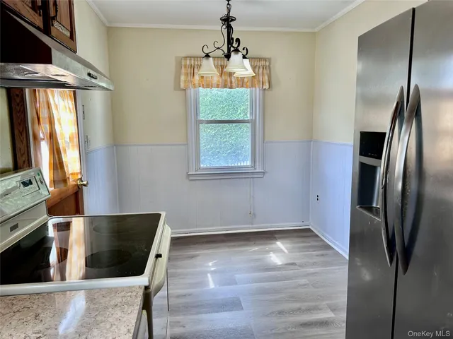 a kitchen with stainless steel appliances granite countertop a refrigerator a stove and a wooden floors