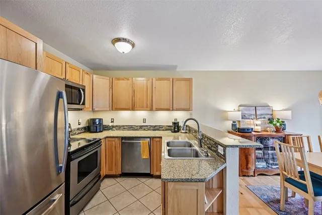 a kitchen with stainless steel appliances granite countertop a refrigerator stove microwave and sink