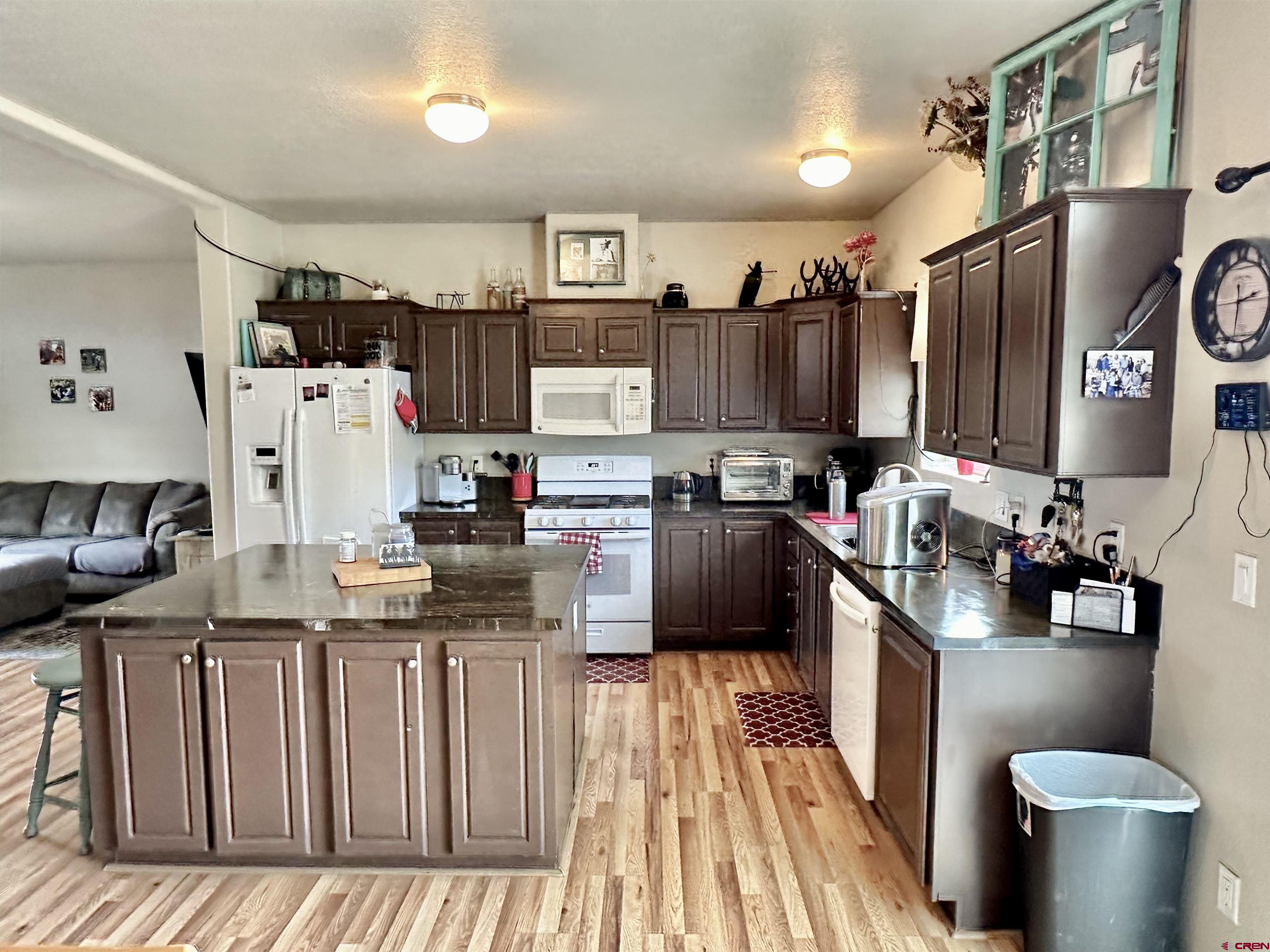 1678 Log Cabin Road Delta, CO 81416 - Photo 14 of 35 a kitchen with stainless steel appliances kitchen island granite countertop a refrigerator a stove and a sink