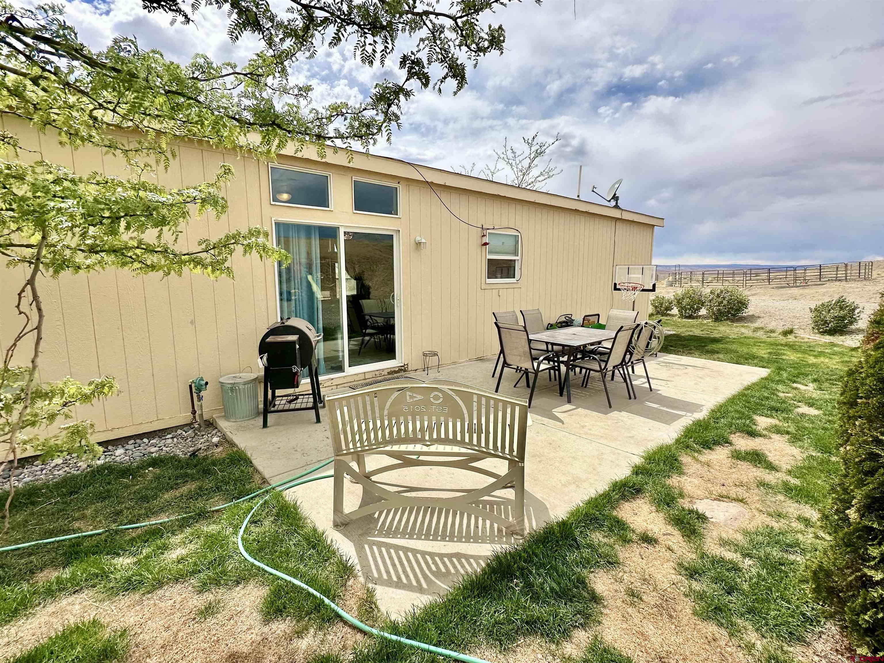 1678 Log Cabin Road Delta, CO 81416 - Photo 33 of 35 a view of a patio with dining table and chairs with wooden floor and fence