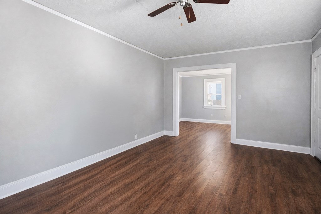 1404 18th Street Columbus, GA 31901 - Photo 3 of 20 an empty room with wooden floor ceiling fan and window
