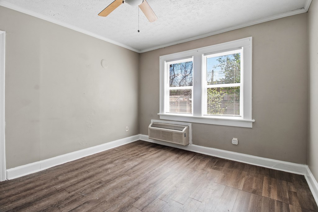 1404 18th Street Columbus, GA 31901 - Photo 6 of 20 an empty room with wooden floor and windows