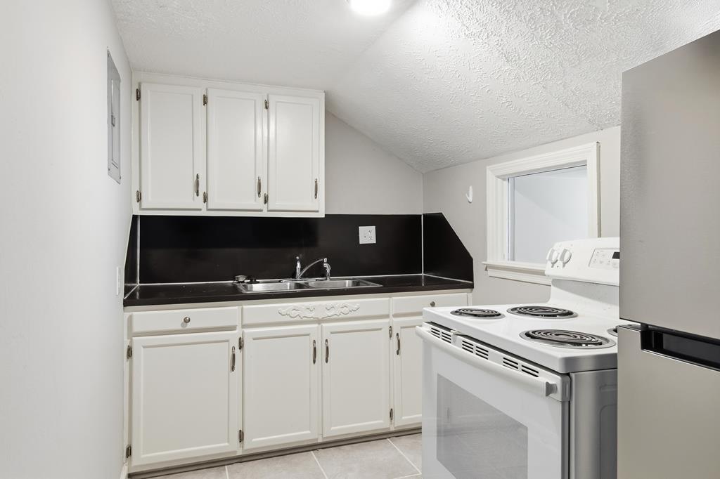 1404 18th Street Columbus, GA 31901 - Photo 10 of 20 a kitchen with granite countertop white cabinets and black appliances