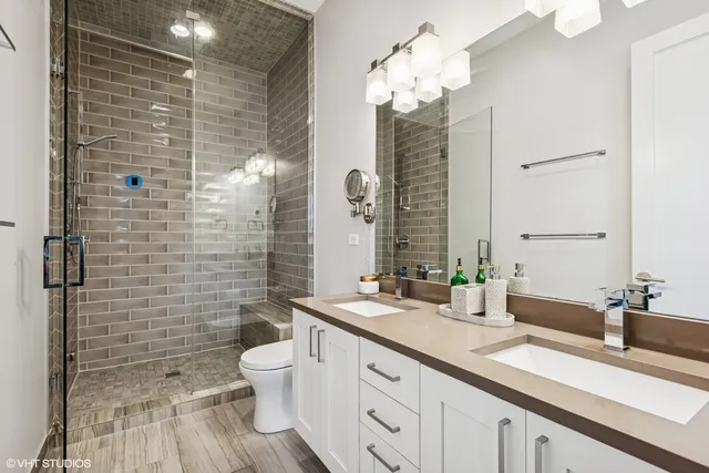 a bathroom with a double vanity sink mirror and toilet