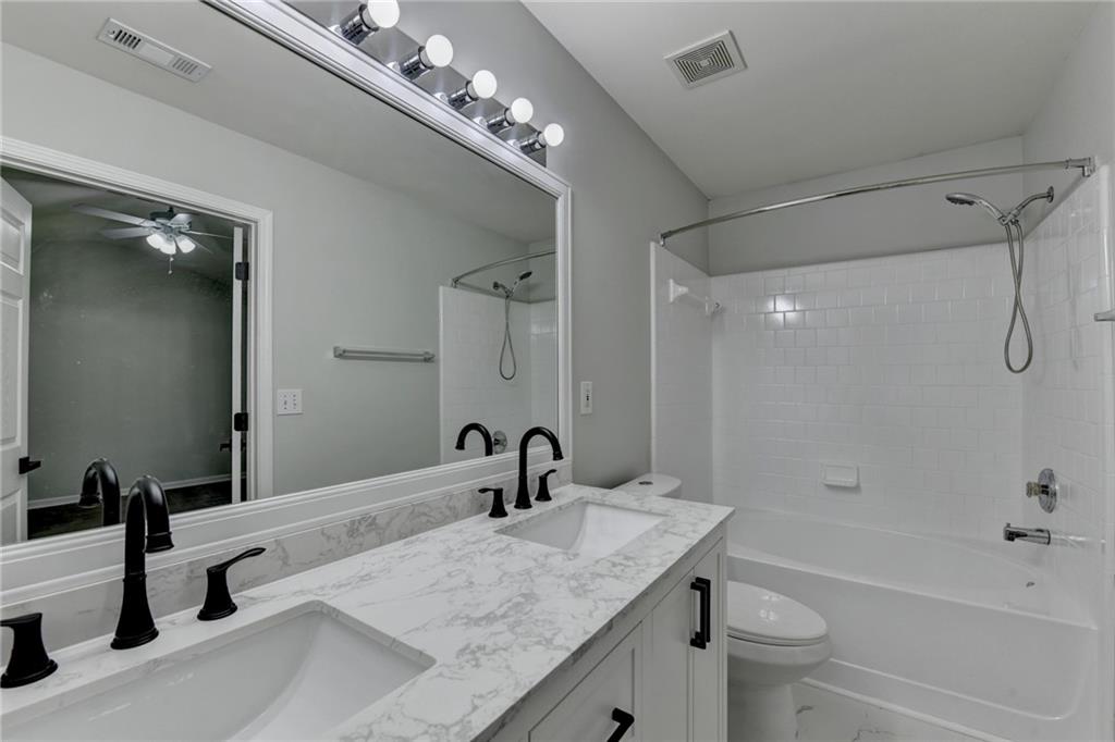 3977 Howell Park Road Duluth, GA 30096 - Photo 19 of 25 a bathroom with a granite countertop sink a toilet and shower
