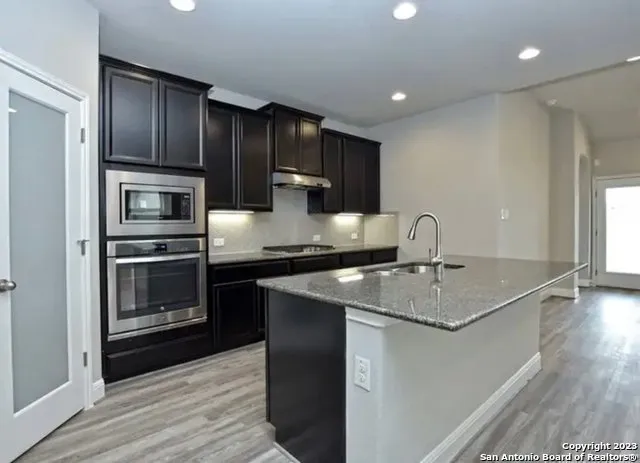 a kitchen with stainless steel appliances granite countertop a sink stove and refrigerator