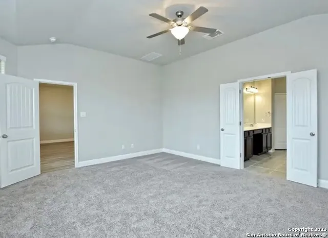 an empty room with closet and a ceiling fan