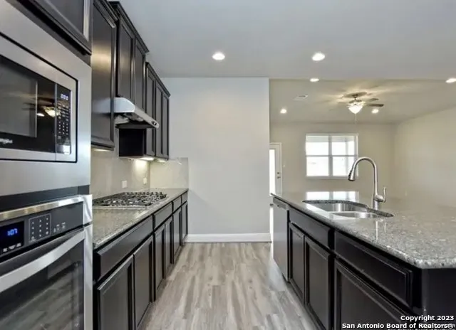 a kitchen with stainless steel appliances granite countertop a sink stove and refrigerator