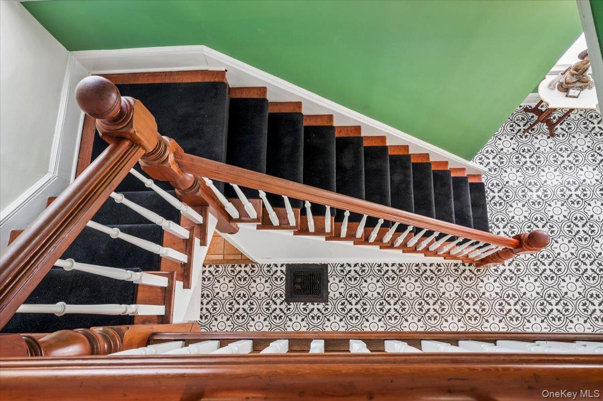 46 Bedford Road Katonah, NY 10536 - Photo 20 of 34 Grand staircase featuring a natural wood banister, white balusters, and a black carpet runner