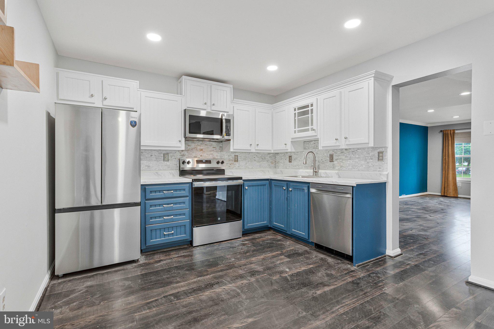 1675 Ridgely Court, Unit 182 Crofton, MD 21114 - Photo 26 of 47 a kitchen with kitchen island a refrigerator sink and cabinets