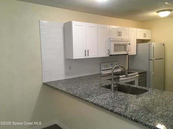 a kitchen with stainless steel appliances granite countertop a sink a stove and a microwave oven
