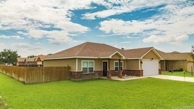 a view of a house with a big yard plants and large trees