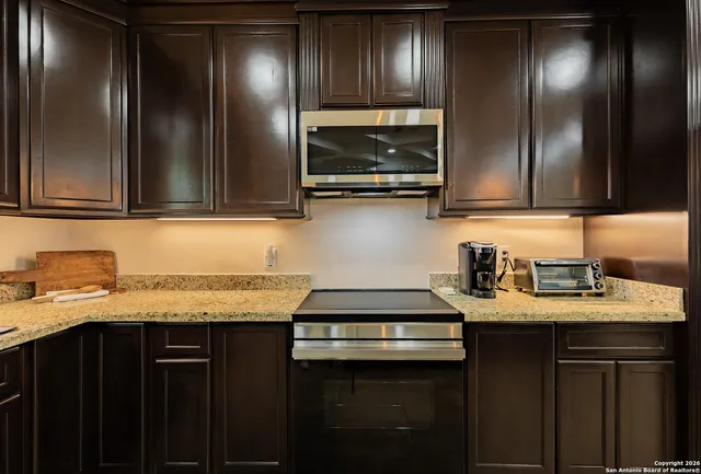 a kitchen with granite countertop stainless steel appliances and cabinets