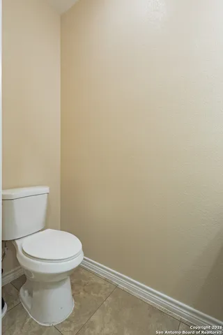 a white toilet sitting next to a white wall
