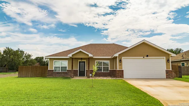 a front view of a house with a garden and yard