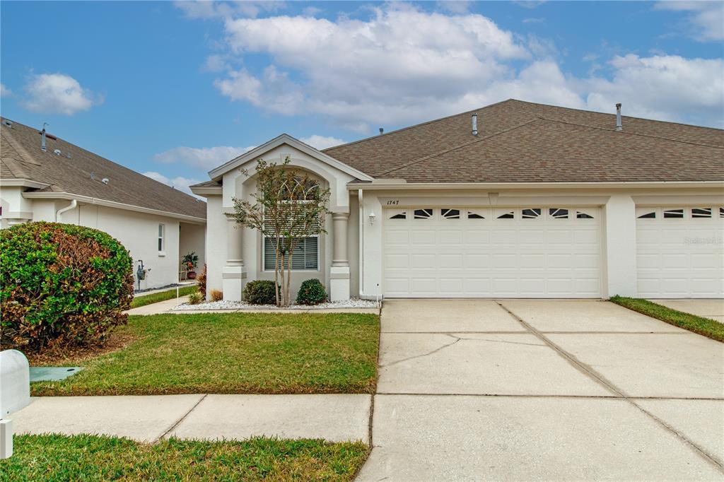 1747 Ravenridge Street Wesley Chapel, FL 33543 - Photo 1 of 35 a front view of a house with garden