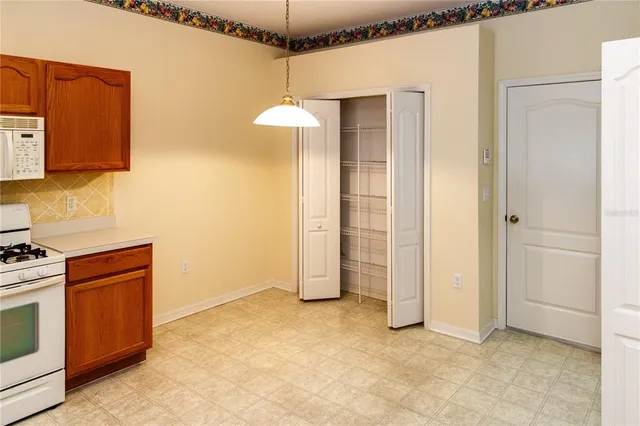 a kitchen with refrigerator a stove a microwave and white cabinets