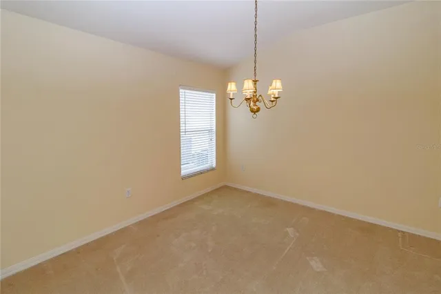 a view of a livingroom with a chandelier wooden floor and chandelier