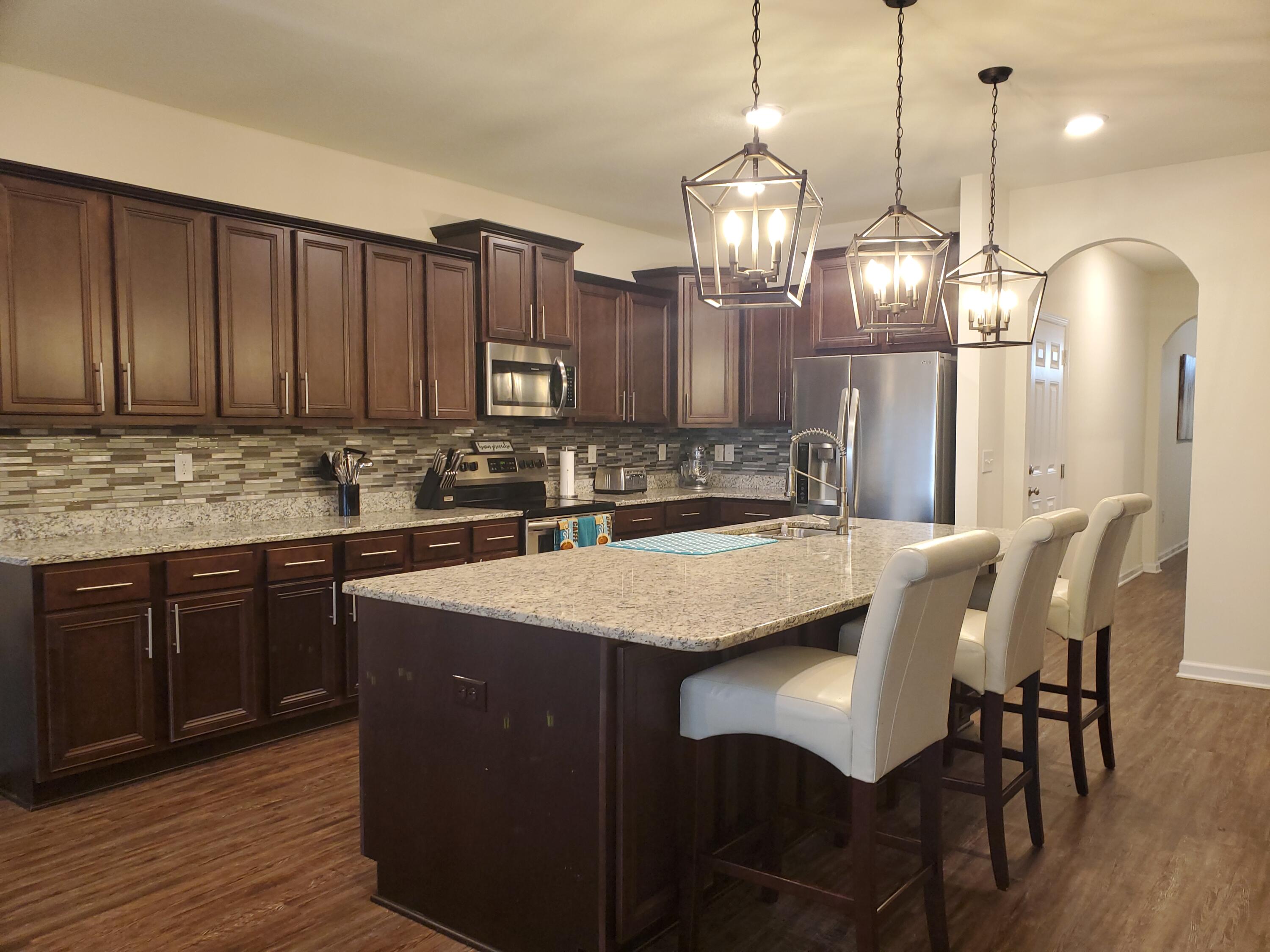 329 Merlin Court Crestview, FL 32539 - Photo 12 of 35 a kitchen with kitchen island granite countertop a sink a center island and cabinets