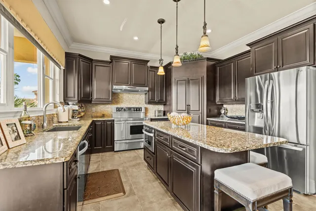 a open kitchen with stainless steel appliances granite countertop a sink and a refrigerator