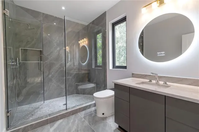 a bathroom with a toilet a sink and mirror