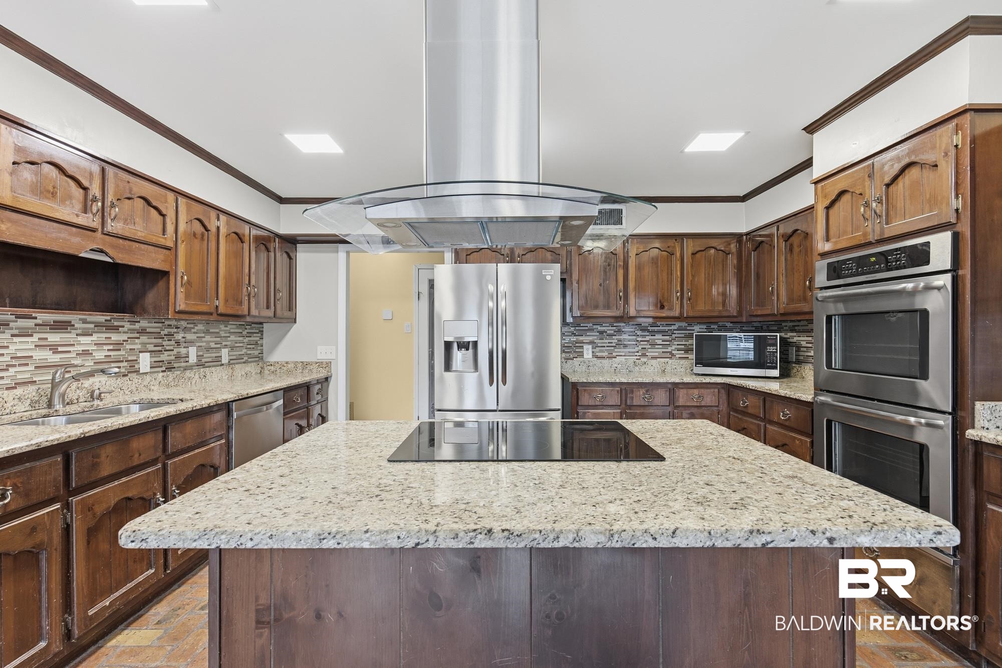 9215 Shiloh Drive Mobile, AL 36695 - Photo 6 of 32 Kitchen with ornamental molding, island range hood, backsplash, stainless steel appliances, and a kitchen island