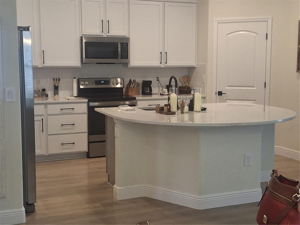 12618 Vander Way New Port Richey, FL 34654 - Photo 5 of 22 a kitchen with cabinets appliances a sink and a counter top space