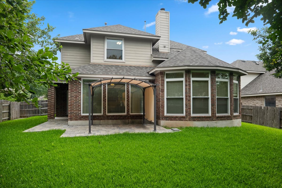 2304 Village View Loop Pflugerville, TX 78660 - Photo 5 of 40 A neatly maintained backyard with a paved patio area, ideal for outdoor enjoyment.