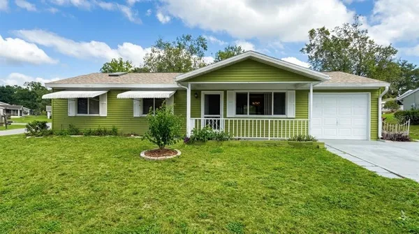 a view of a house with a yard and potted plants