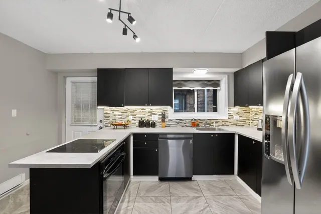 a kitchen with stainless steel appliances granite countertop a sink and a stove