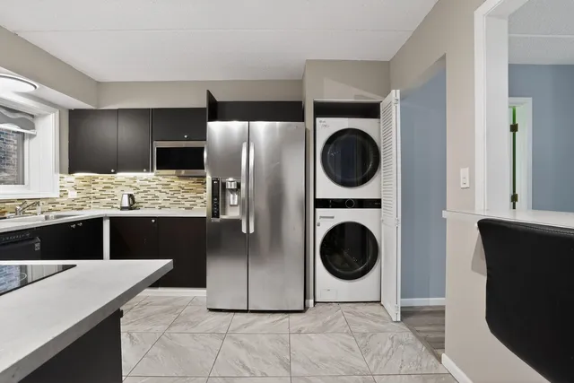 a spacious bathroom with a granite countertop sink and a washing machine