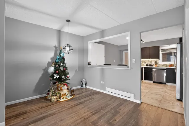 a view of a room with wooden floor and a kitchen