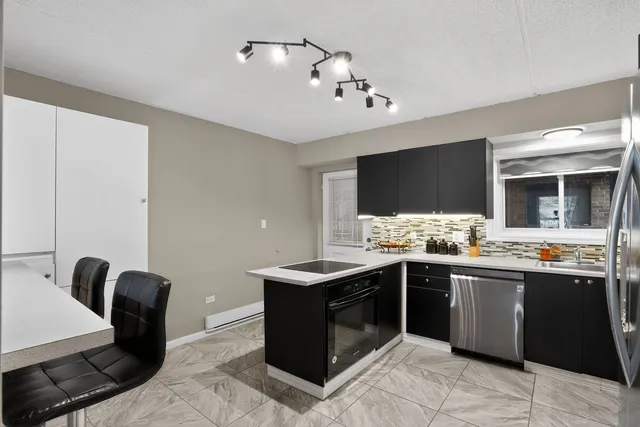 a kitchen with a sink and chairs
