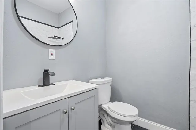 a bathroom with a sink a toilet and a mirror