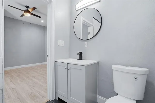 a bathroom with a toilet a sink and a mirror