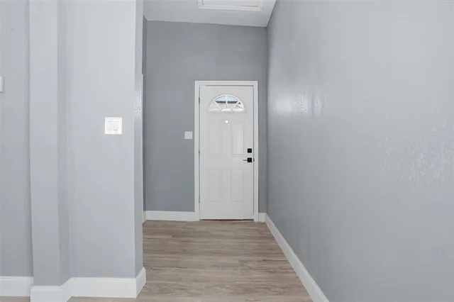 a view of a hallway with wooden floor