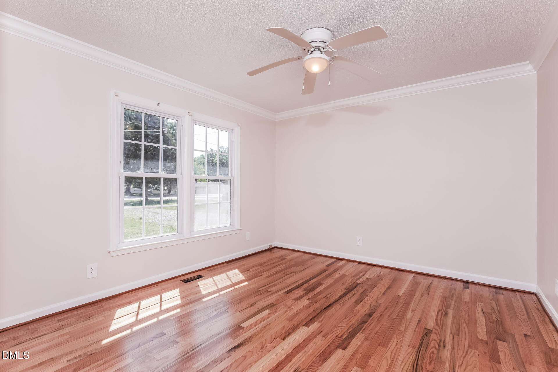 870 Abbott Road Henderson, NC 27537 - Photo 6 of 20 an empty room with wooden floor fan and windows