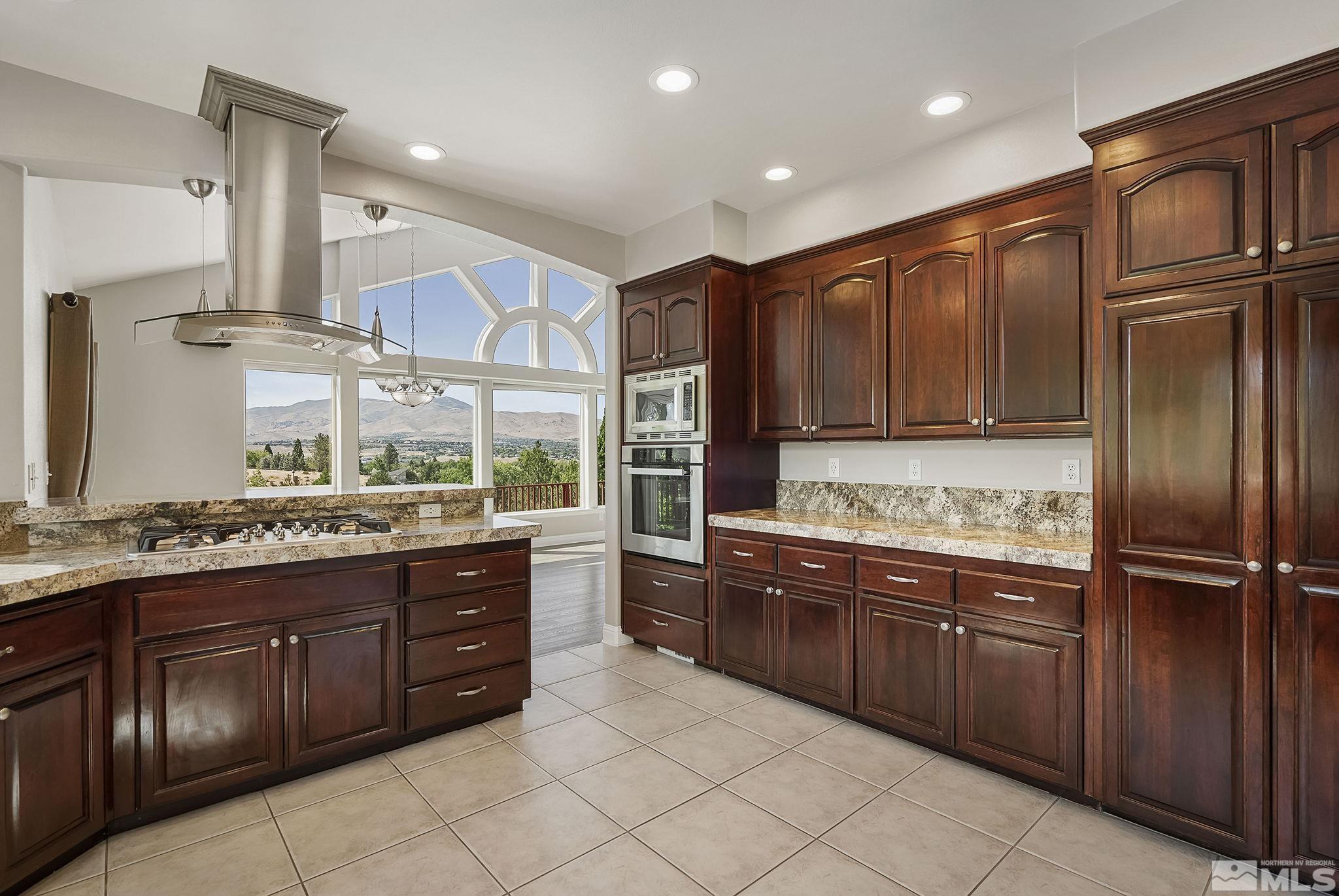 2215 Andromeda Way Reno, NV 89509 - Photo 4 of 40 a kitchen with stainless steel appliances granite countertop wooden cabinets and sink