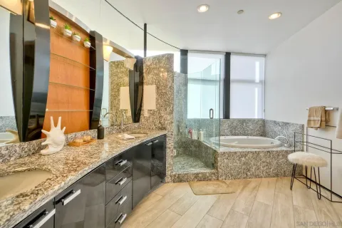a bathroom with a granite countertop sink and a large mirror