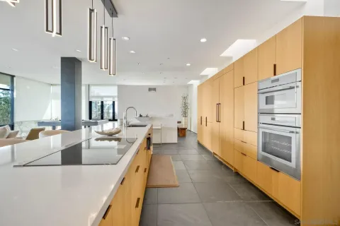 a large kitchen with stainless steel appliances kitchen island granite countertop a large counter top and living room