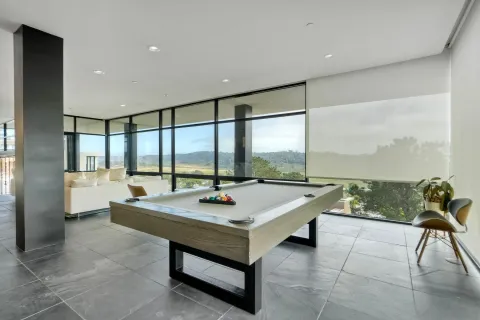 a living room with dining table furniture and a floor to ceiling window