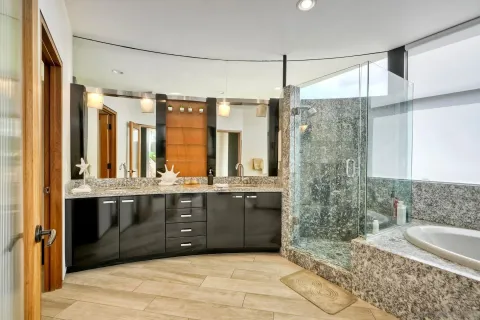 a bathroom with a granite countertop sink and a bathtub