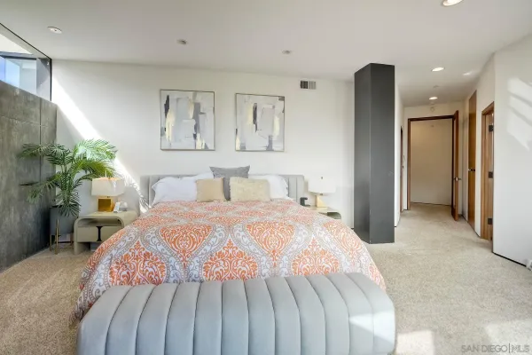 a bedroom with a large bed and a chandelier