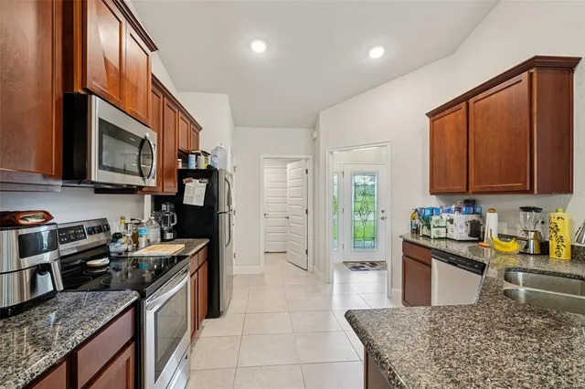 a kitchen with stainless steel appliances granite countertop a refrigerator a stove top oven a sink and dishwasher