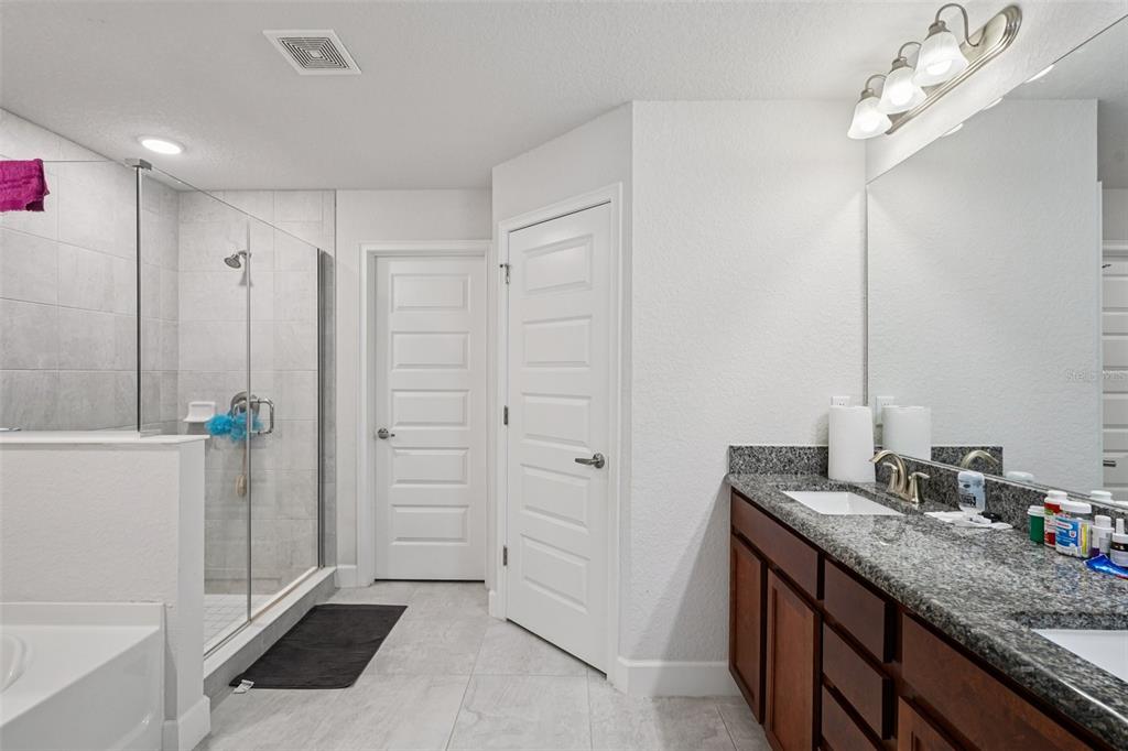 67 Northwest 45th Loop Ocala, FL 34475 - Photo 19 of 27 a bathroom with a granite countertop sink a mirror and a shower