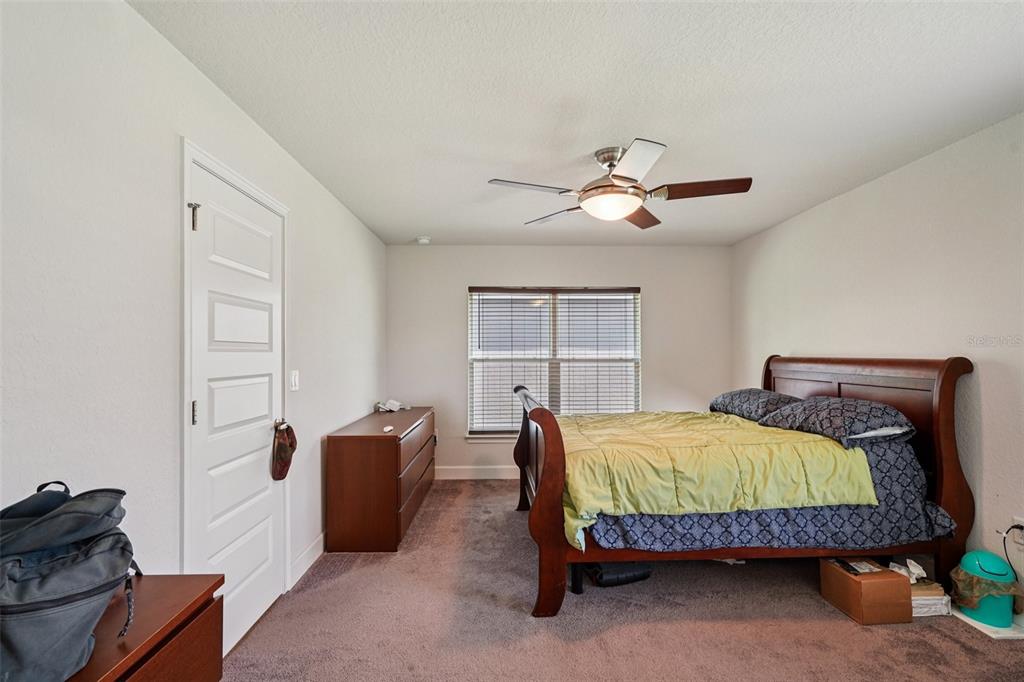 67 Northwest 45th Loop Ocala, FL 34475 - Photo 5 of 27 a bedroom with a bed and a chandelier