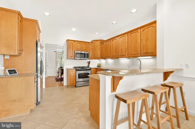 a kitchen with stainless steel appliances granite countertop a refrigerator and a stove top oven